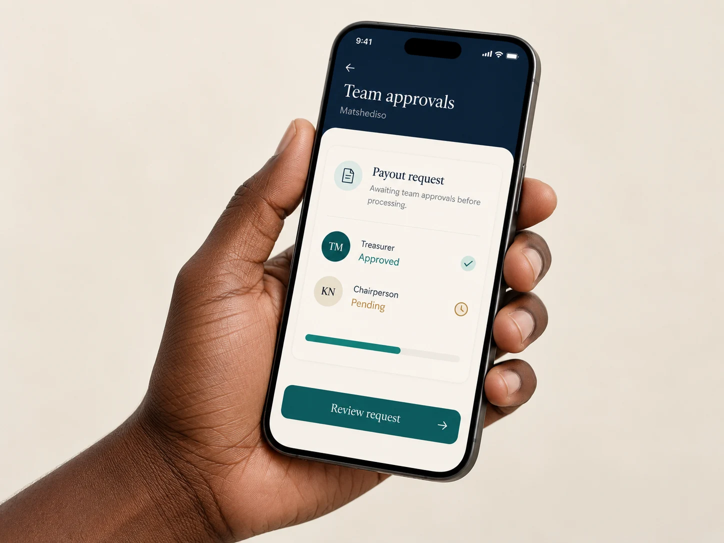 Black adult hand holding a smartphone showing an illustrative payout request awaiting a second team approval